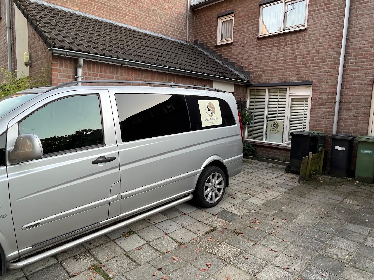 De praktijkruimte van Haarstudio Ellen naast het woonhuis, met het bedrijfsbusje ervoor geparkeerd